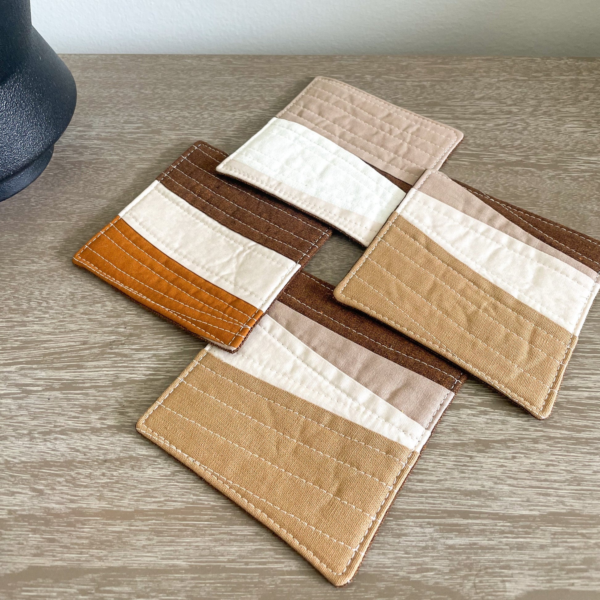 quilted coasters_rust and natural set of 4 on a table